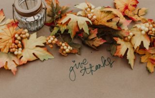 Fall leaves and lamp on butcher paper with a sign that says 'Give Thanks'